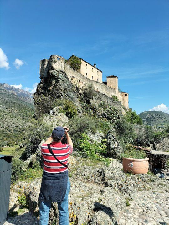 Customer taking pictures of the citadel of Corte, during a private VTC excursion from Ajaccio.