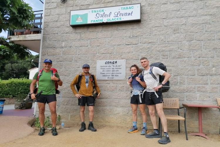 Traslado privado VTC desde el aeropuerto de Ajaccio a Conca, salida del GR20 Sud para 4 excursionistas frente a la señal de Conca y el Bar du Soleil Levant en Córcega.