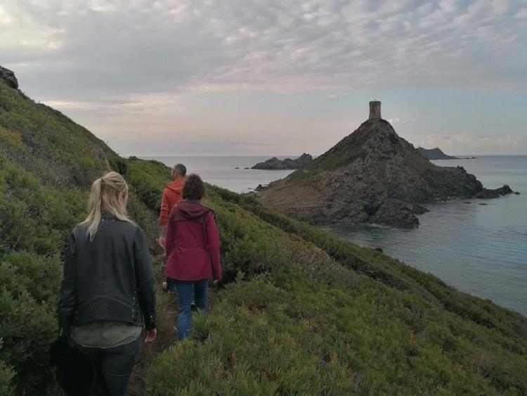Guide local et clients se baladant vers la tour de la Parata aux îles sanguinaires, au cours d'une excursion privée VTC depuis Ajaccio